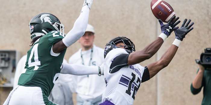 JJ Jefferson extends for the over the shoulder grab over the Michigan State Spartan.